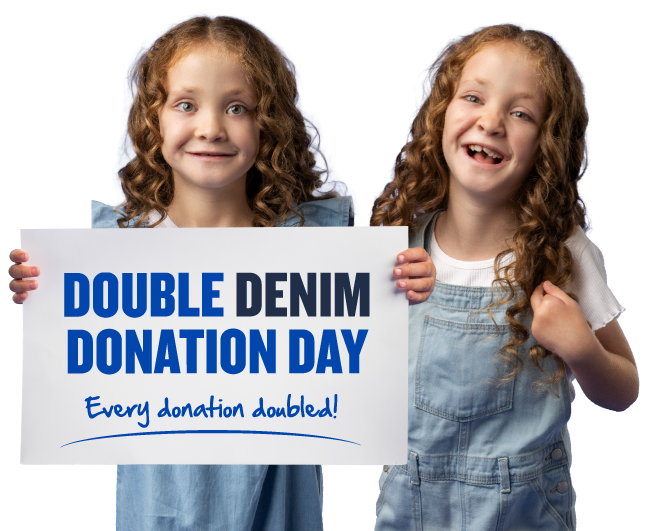 Two children wearing denim overalls, holding a sign that reads: 'DOUBLE DENIM DONATION DAY – Every donation doubled!' Two children wearing denim overalls, holding a sign that reads: 'DOUBLE DENIM DONATION DAY – Every donation doubled!'